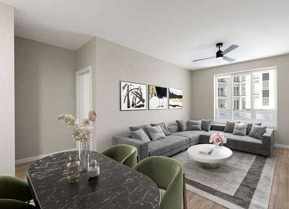 a living room with a gray couch and a dining table