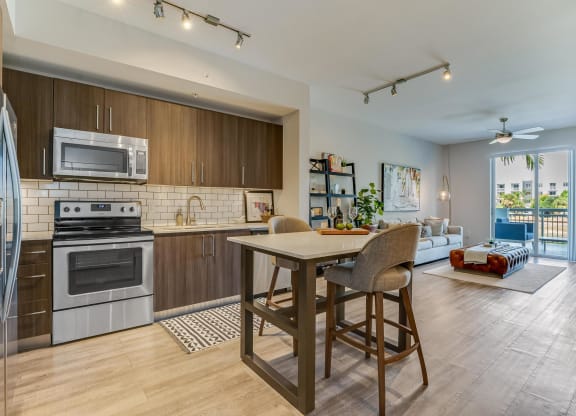 Kitchen and Living Room View with Island and Private Balcony Access