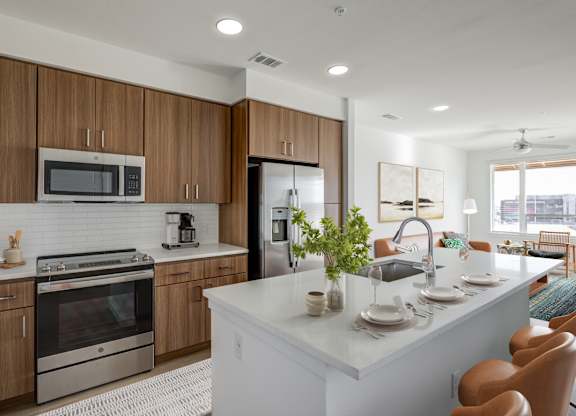 a kitchen with a large island and stainless steel appliances
