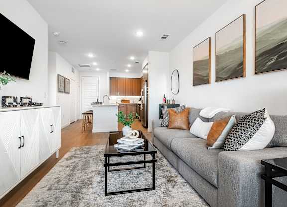 A modern living room with a grey couch and a coffee table.