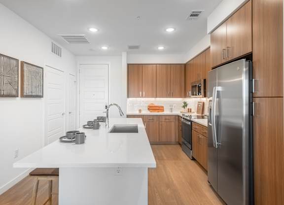 A modern kitchen with wooden cabinets and stainless steel appliances.