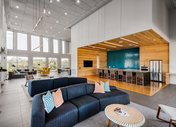 A modern living room with a blue couch and a wooden coffee table.
