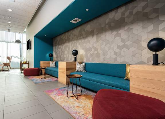 A modern living room with a blue couch and a wooden floor.