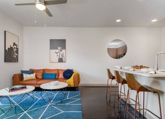 A living room with a blue rug and a white table.