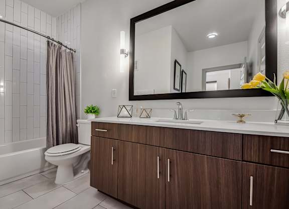 A bathroom with a white toilet, a sink, and a mirror.