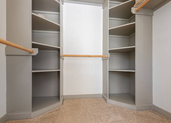 A walk-in closet with shelves and a carpeted floor.