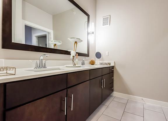 A bathroom with a sink, mirror, and cabinets.