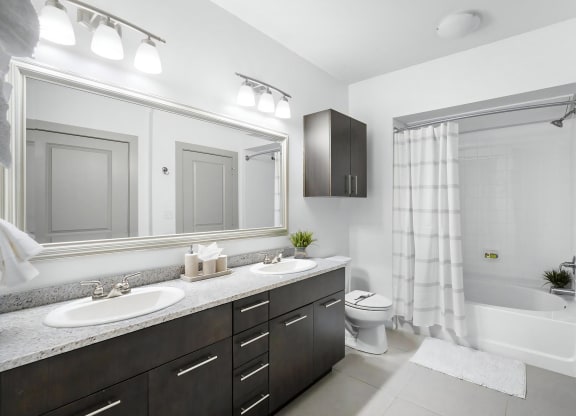 Bright Bathroom with Dual Vanities, Tile Floors, and Shower-Tub Combo
