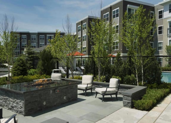 Outdoor Lounge Area with Stone Firepit and Padded Seating