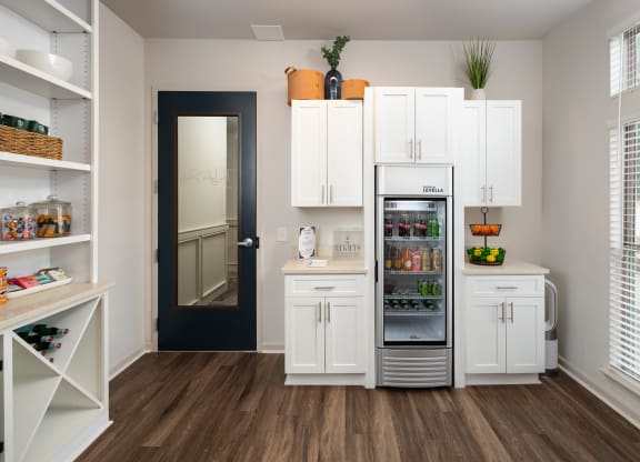 a kitchen with white cabinets and a refrigerator and a door