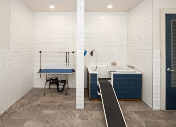 a locker room with a sink and a bath tub and aigmigmigmot