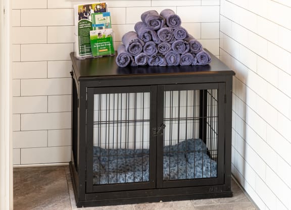 a dog cage with purple blankets on top of it