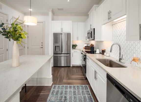 a large white kitchen with stainless steel appliances