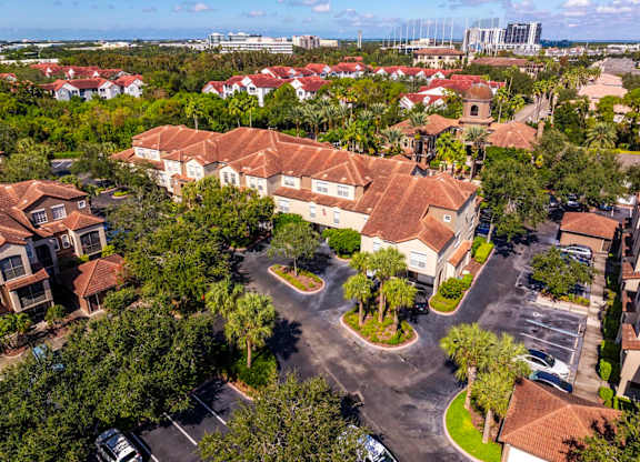 Aerial of apartment buildings with terracotta roofs and parking areas