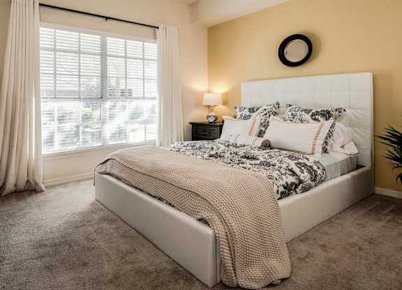 Bright bedroom with upholstered bed and large window