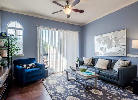 Living room with blue walls, leather sofa and balcony light