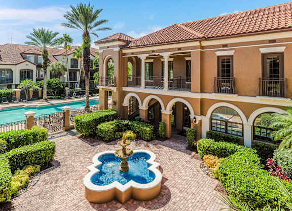 Resort-style courtyard with fountain and pool views surrounded by manicured landscaping.