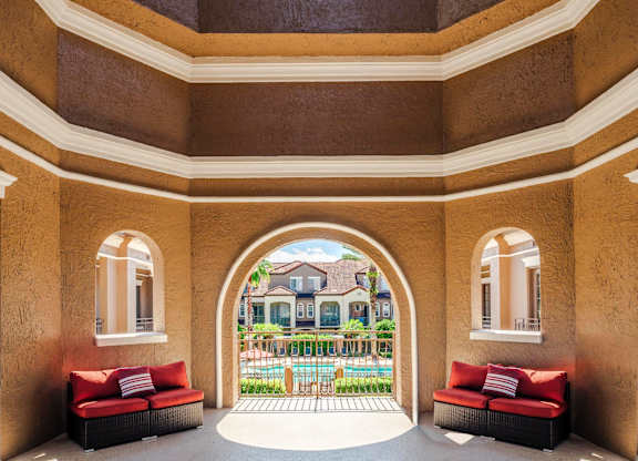Covered seating area overlooking the pool and courtyard, perfect for relaxing outdoors.
