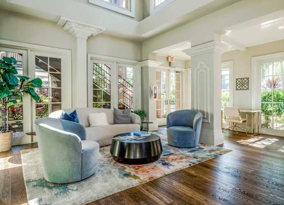 Elegant clubhouse seating area with large windows, plush chairs, and inviting design.