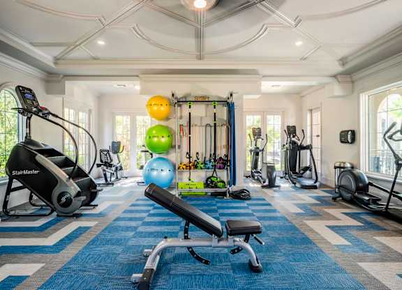 Spacious fitness center with stair climber, free weights, and functional training equipment.