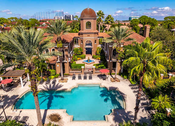 Aerial of courtyard and pool framed by palm trees and lounge seating