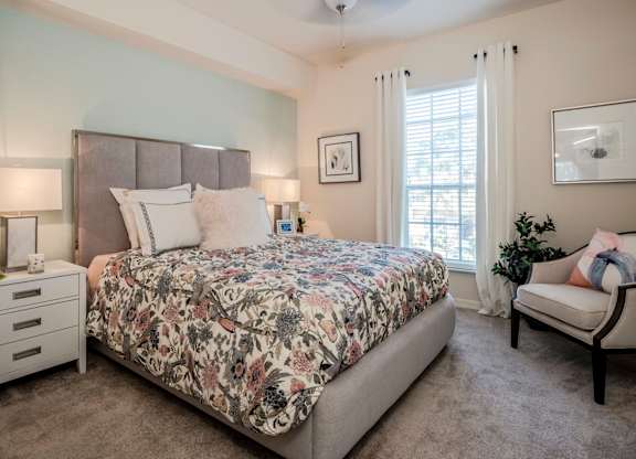 Bedroom with upholstered headboard, floral bedding and soft natural light