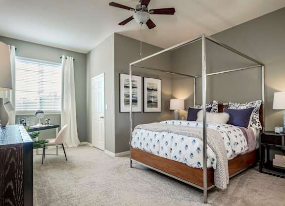 Bedroom with modern canopy bed, desk nook and natural light