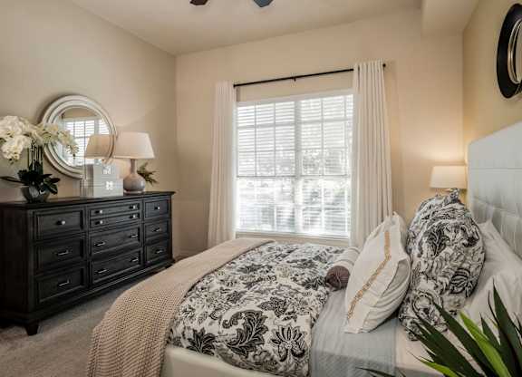 Cozy bedroom with dresser, mirror and soft window light