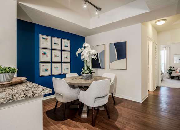 Dining area with gallery wall, round table and orchid centerpiece