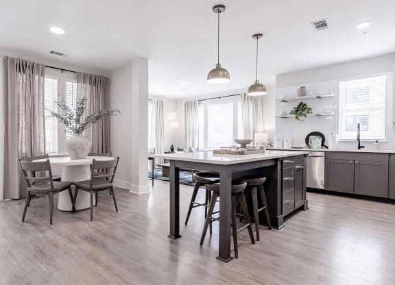 Bright kitchen area with dark wood accents and white countertops at Novel Cary