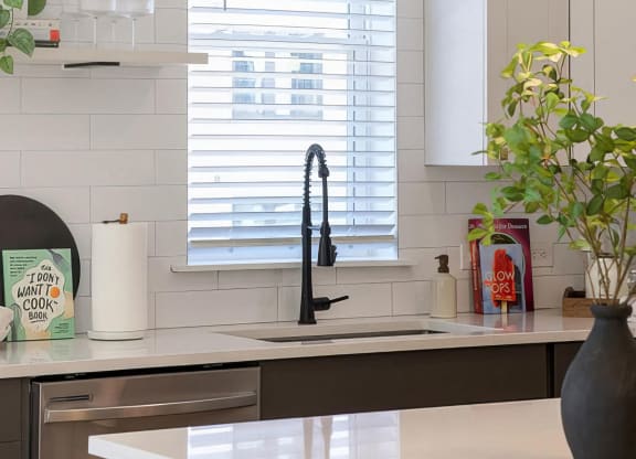 Clean kitchen with stainless steel appliances and modern shelving at Novel Cary