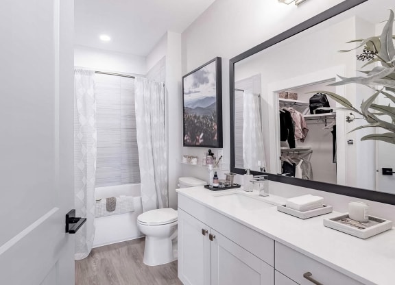 Full bathroom with a bathtub with tile backdrop at Novel Cary