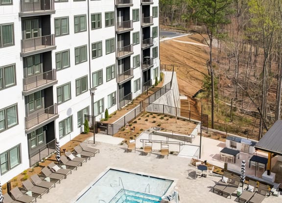 Large outdoor saltwater pool with deep and shallow areas and lounge seating at Novel Cary