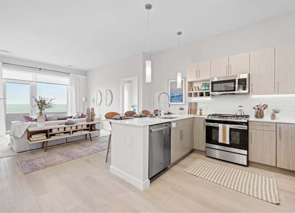 A modern kitchen with a dining area and a view of the beach.