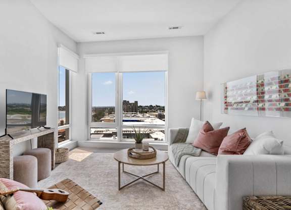 A living room with a flat screen TV and a view of the city.