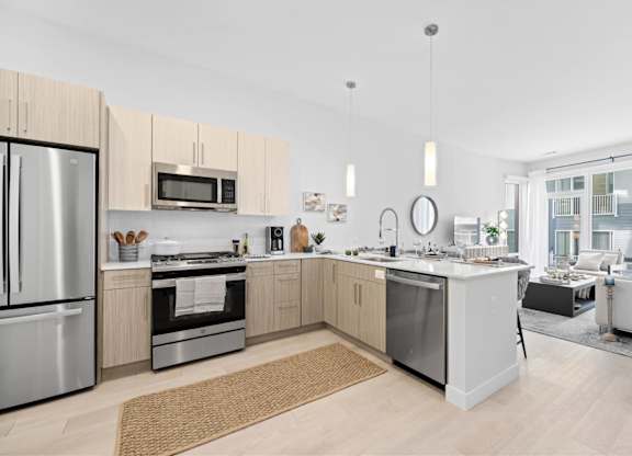 A modern kitchen with a refrigerator, oven, and microwave.