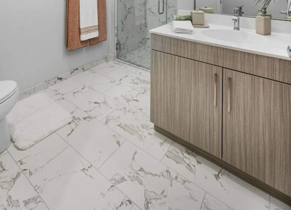 A bathroom with a toilet, sink, and a mirror.