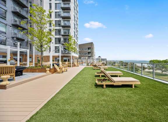 A grassy area with benches and a fence in front of a building.