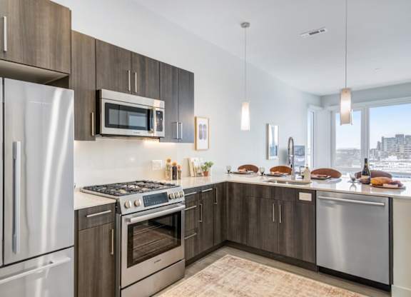 A penthouse modern kitchen with stainless steel appliances and wooden cabinets.