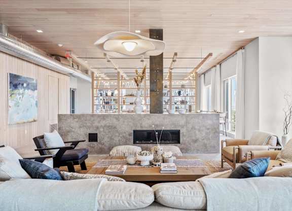 A modern living room with a fireplace and a large painting on the wall.