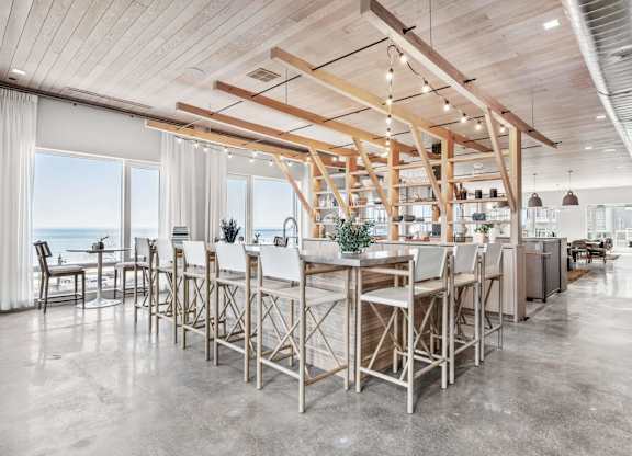 A modern kitchen with a large island and wooden beams on the ceiling.