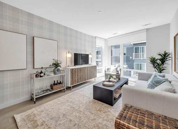 A modern living room with a large window and a balcony.