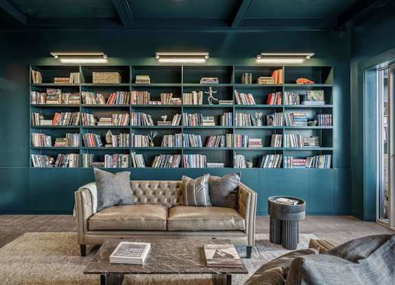 A living room with a couch, a coffee table, and a bookshelf filled with books.