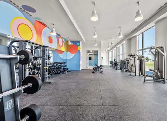 A gym with a variety of equipment including weights and machines.