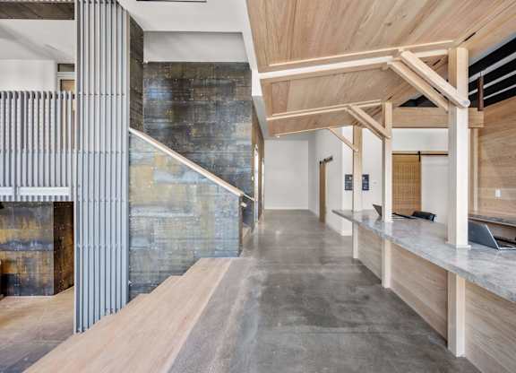 A modern interior with a wooden ceiling and a concrete wall.