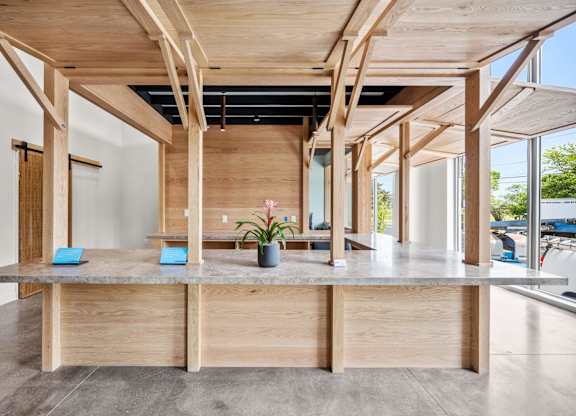 A wooden table with a plant on it in a room with wooden beams.