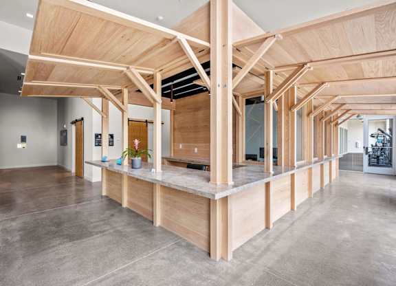 A large open space with a wooden beam ceiling and concrete flooring.