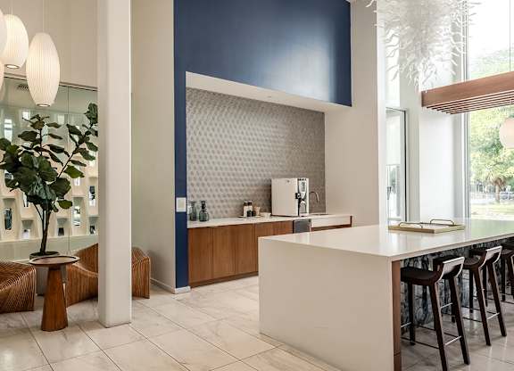 Tenant lounge area with modern seating and kitchen area at Pearl Flagler Village