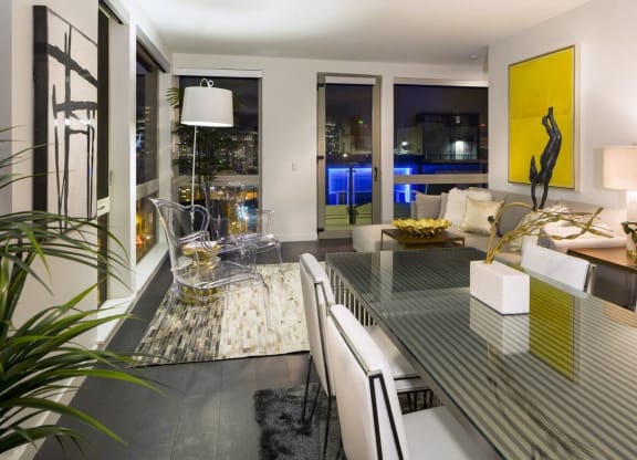 a living room and dining room with a glass table
