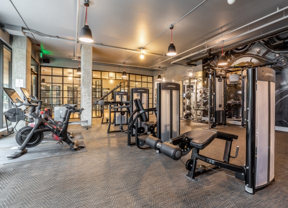a gym with weights and exercise equipment in a building with glass doors
